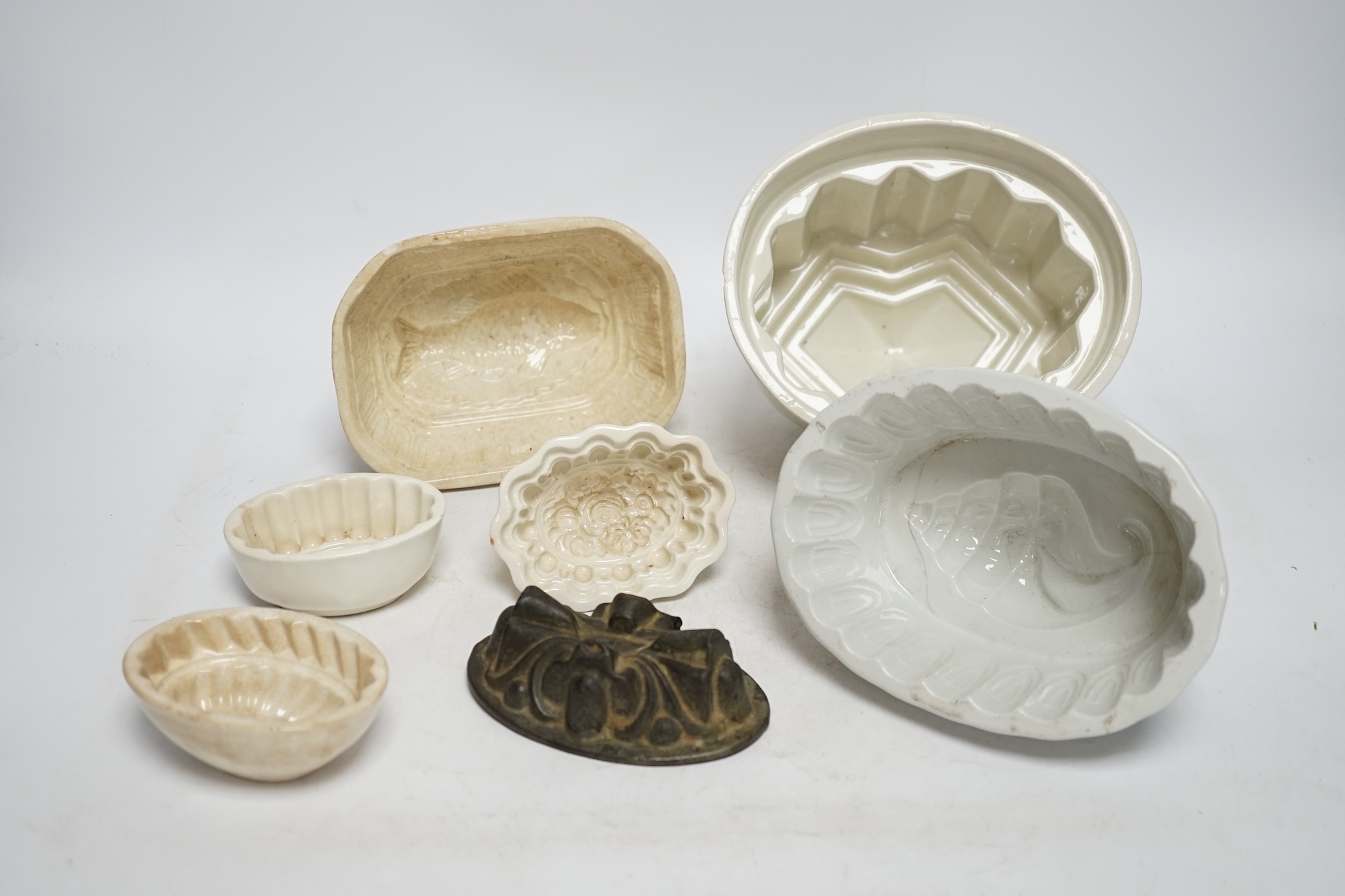 From the Studio of Fred Cuming. Seven jelly moulds including six ceramic examples, one Cetemware, largest 17cm wide. Condition - fair, one cracked